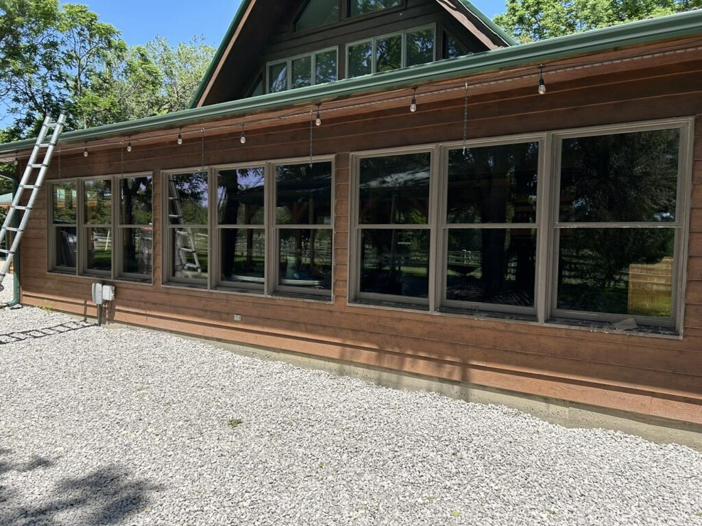 Large clean windows on a wood-sided home